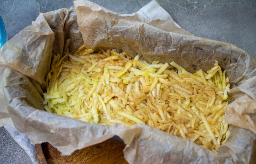 1. Этап. Насыпной яблочный пирог: Сверху ровным слоем распределите третью часть натертых яблок, слегка утрамбуйте.