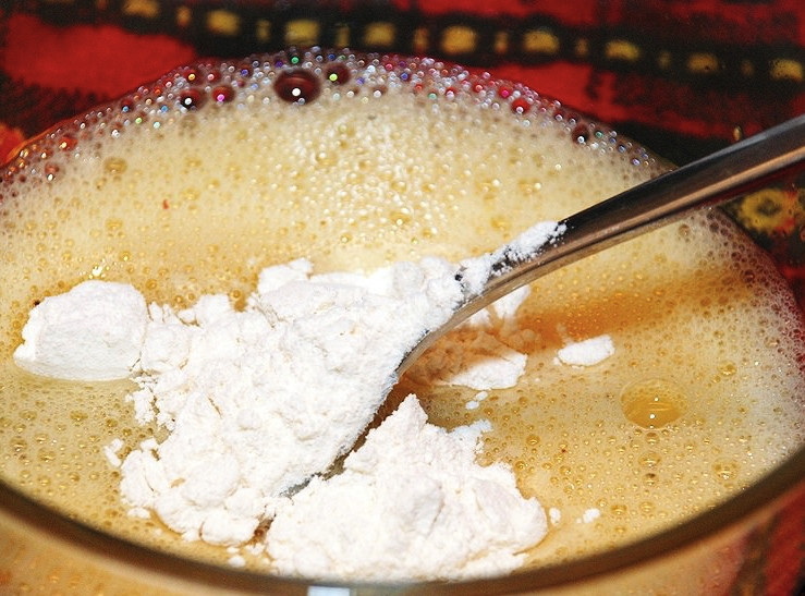 1. Этап. Кальмары в масле: Теперь займитесь приготовлением кляра. Для этого хорошо взбейте яйцо вилкой или венчиком. К яйцу добавьте вино, муку и соль с перцем по вкусу. Всё тщательно взбейте.