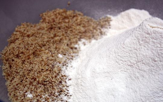 1. Этап. Будайский творожник: Смешиваем в таре просеянную муку, измельченные в блендере грецкие орехи, тертую цедру и сливочное масло. Пальцами смешиваем все в крошку.