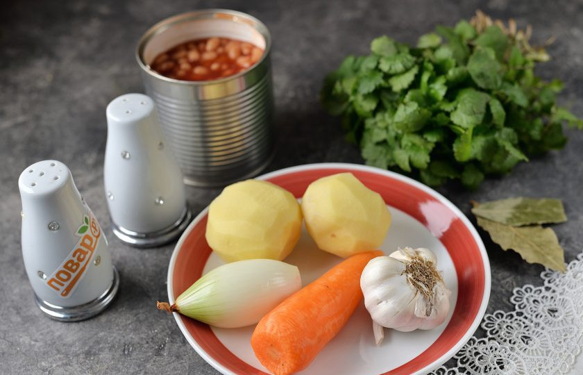 1. Этап. Фасолевый суп с кинзой: Подготовьте все необходимые ингредиенты для приготовления супа. Лук, чеснок, морковь и картофель почистите, помойте вместе с кинзой под проточной водой. Фасоль лучше использовать в томатном соку, с ней суп получится вкуснее.