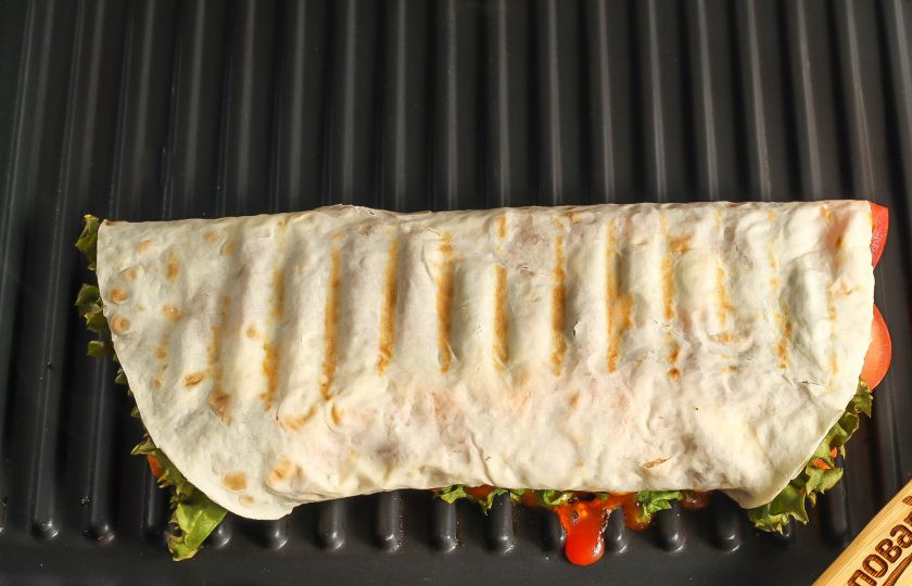 1. Этап. Цезарь ролл с наггетсами: Выложите ролл на панель или на сковороду и обжарьте до румяных полосочек.