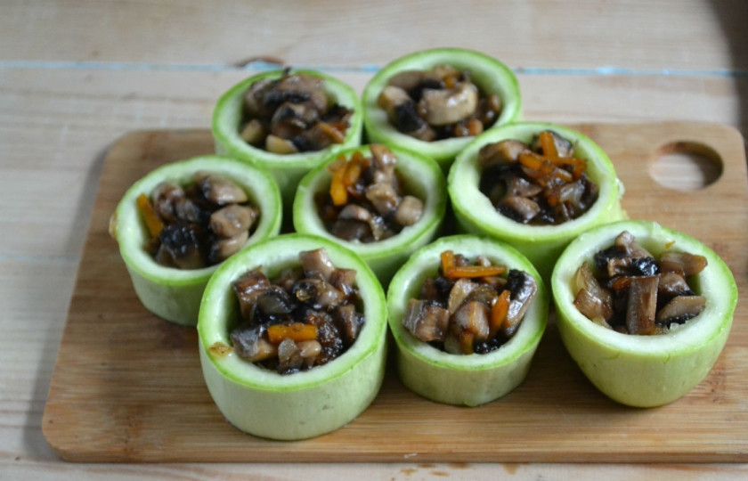 1. Этап. Фаршированные кабачки в духовке: Наполните подготовленной начинкой заготовки из кабачков. Присыпьте сверху тертым твердым сыром. Разогрейте духовку до 180-190 градусов и запеките блюдо. Время запекания составляет около 30 минут.