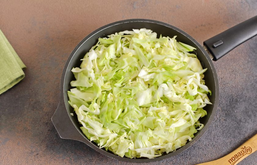 1. Этап. Капустный пирог, который тает во рту: В сковороде разогрейте масло, выложите нашинкованную тонко капусту и тушите до мягкости.