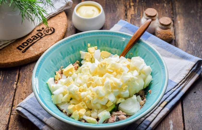 1. Этап. Салат из консервированной сайры: Куриное яйцо отварите вкрутую, очистите и нарежьте кубиками, добавьте к остальным ингредиентам.