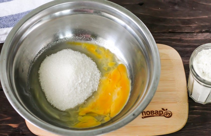 1. Этап. Печенье с грецкими орехами: Вбейте в миску куриное яйцо, всыпьте щепотку соли и 80 грамм сахарного песка. Тщательно взбейте примерно 1-2 минуты.