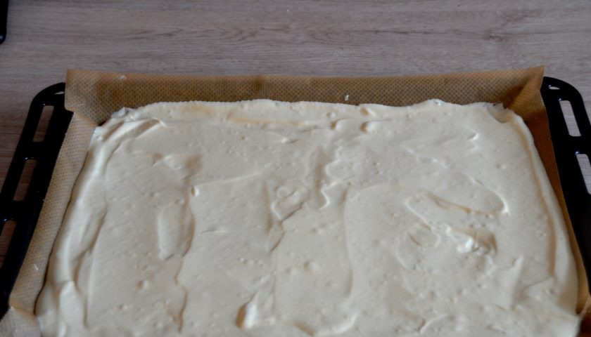 1. Этап. Торт Полено с вишней: Выложите тесто на противень с пергаментом или с силиконовым ковриком. Хорошо разровняйте, чтобы при выпечке бисквит получился ровным. Выпекайте в предварительно разогретой до 180 градусов духовке в течение 20 минут.