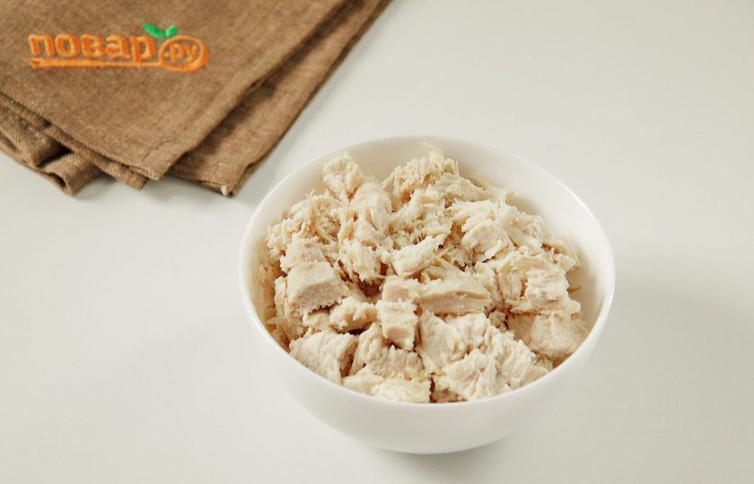 1. Этап. Слоеный салат Новогодний: Нарежьте грудку небольшими кусочками или разберите на волокна.