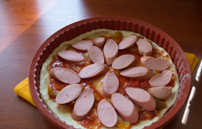 1. Этап. Пицца с сосисками: Корж пиццы смазать томатным соусом. Выложить нарезанный болгарский перец, сосиски. Перец можно взять и замороженный.