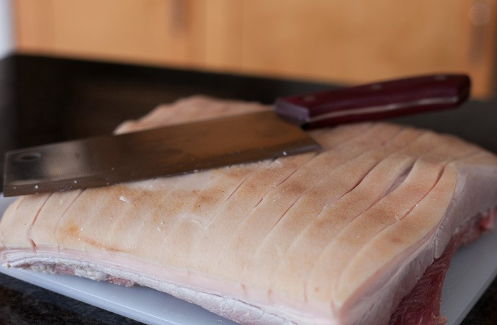 1. Этап. Свинина запеченная с чесноком: Рецепт немного усложненный, но оно того стоит. Итак, для начала нужно окатить кипятком ту часть грудинки, на которой кожа. Хорошо окатить, равномерно всю поверхность кожи. Затем нужно насухо просушить кожу и острым ножом (тупым не получится) сделать неглубокие надрезы на коже. Так, как показано на фото (поперечные надрезы в сантиметре друг от друга).