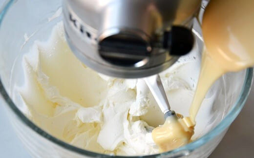 1. Этап. Чизкейк без выпечки с сыром: 3. Для приготовления начинки взбейте крем-сыр со сгущенкой, ванильным экстрактом, соком и цедрой лимона.