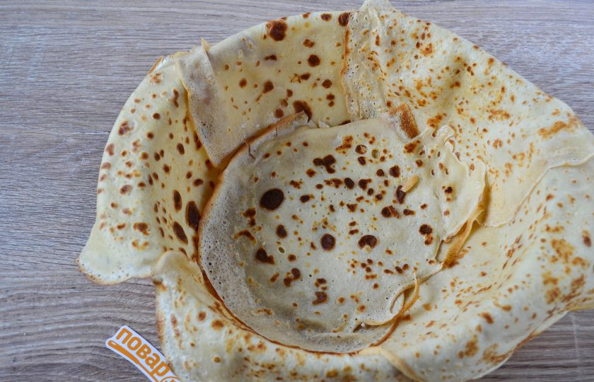 1. Этап. Блинный пирог с курицей и грибами: Жаропрочную форму для запекания смажьте сливочным маслом. Застелите дно формы блином, а затем стенки обложите по кругу блинами, создавая нахлест. Боковые блины свесьте за бортики формы.