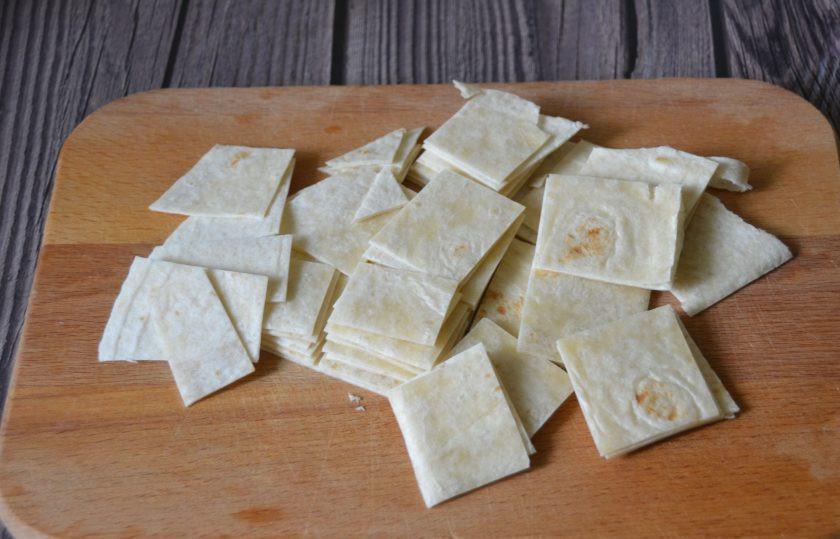 1. Этап. Куриный суп с тортильями: Порежьте две тортильи произвольно, форма нарезки не имеет значения.