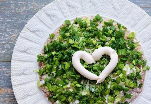 1. Этап. Салат с тунцом Новогодний шар: Зелёный лук промыть, обсушить, мелко нарезать и разложить поверх тунца, смазать майонезом.