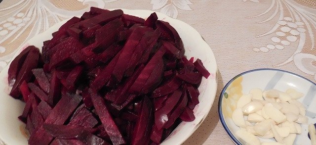 1. Этап. Салат со свеклой на зиму: Чеснок очистите и нарежьте крупными кусочками. Сваренную свеклу нарубите средними брусочками.