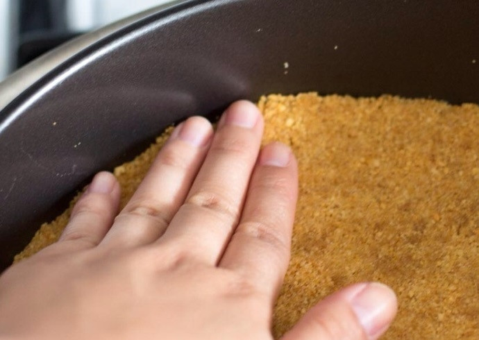 1. Этап. Чизкейк с желе: 2. Уложите полученную массу из печенья в форму для выпечки, придавите руками. Выпекайте при 180 градусах около 15 минут.