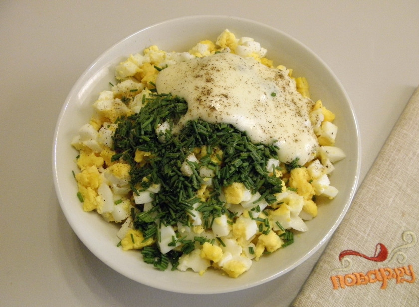 1. Этап. Крабовый салат из крабовых палочек: 6. Лук порежьте мелко, добавьте его в салат. Посолите, поперчите и заправьте салат майонезом. Перемешайте.