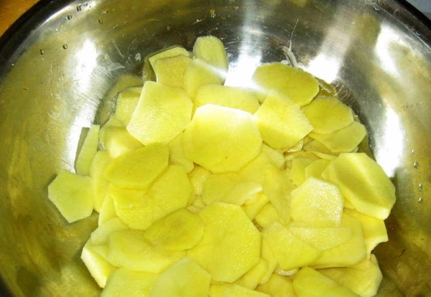 1. Этап. Картошка, запеченная под сыром в духовке: Очистите, промойте и нарежьте пластинками картофель.