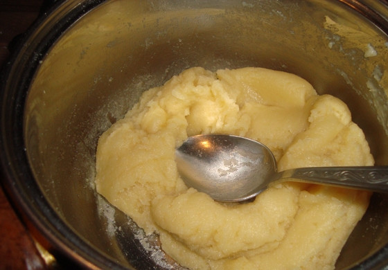 1. Этап. Заварное тесто для торта: 2. Добавьте просеянную муку, хорошо вымешивайте, не снимая с огня, около 2 минут. Мука заварится, и образуется густое плотное тесто. Переложите его в миску, оставьте для остывания до 60 градусов цельсия или просто помешивайте некоторое время, пока не будет достигнута нужная температура.