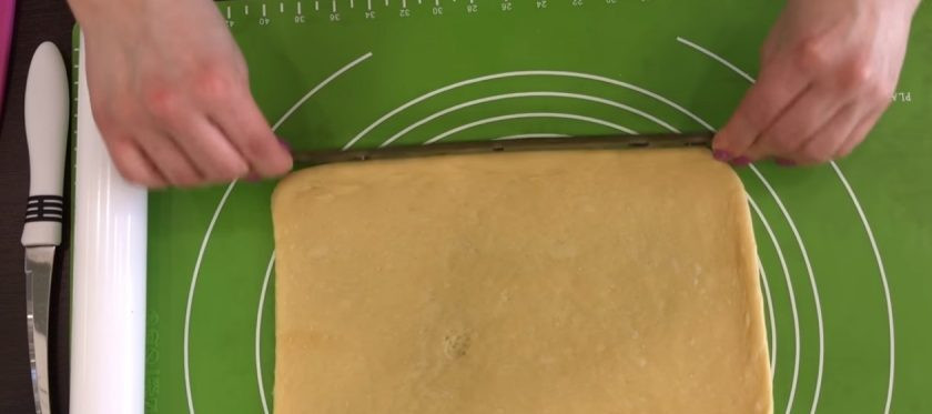 1. Этап. Булочки-плетенки с корицей и маком: 6. Тесто обомните и разрежьте на 4 части. На присыпанной мукой поверхности раскатайте тесто в пласт размером 15х25 см. Выложите маковую начинку на весь пласт теста.