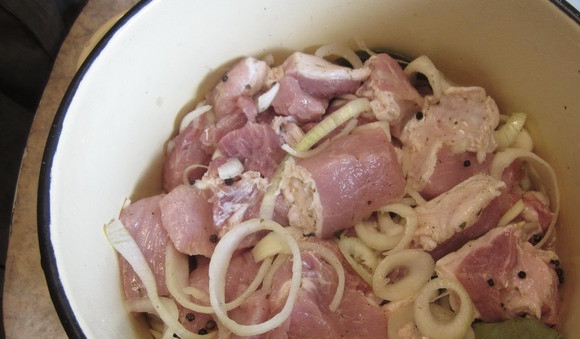1. Этап. Мцвади: В миску сложим нарезанное ранее мясо, сверху укладываем лучок. Добавляем подготовленные в предыдущем шаге ингредиенты (соль, лаврушка, перчик), а также — уксус.