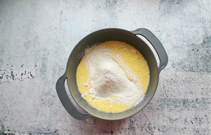 1. Этап. Бисквитное печенье Дед Мороз: Муку смешайте с разрыхлителем и просейте. Частями всыпайте в яичную массу и мешайте аккуратно до однородного теста без комочков.