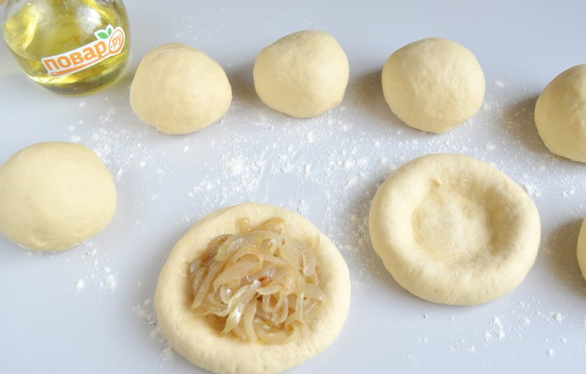 1. Этап. Дрожжевые лепешки с луком: 7. Разделите тесто на 8-10 частей, от желаемого размера лепешек. Я поделила на 8 частей. Скатайте кусочки в шарики. Сделайте руками лепешку с небольшими бортиками. Положите в нее восьмую часть начинки луковой. Также поступите с остальным тестом и луком.