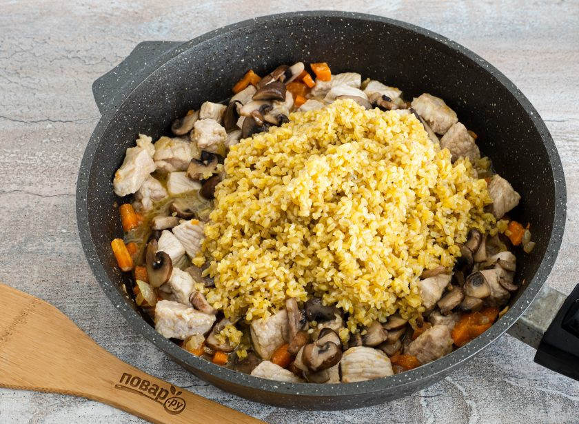 1. Этап. Плов из булгура с грибами: И добавьте промытую крупу. Разровняйте крупу по всей сковороде и залейте водой на 1,5 см. выше уровня крупы.