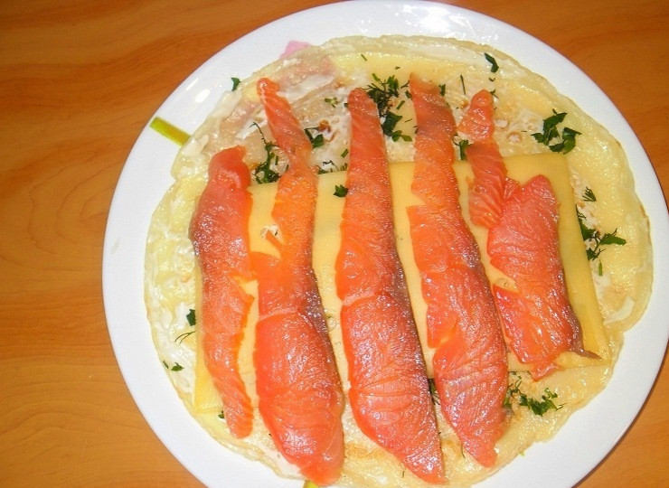 1. Этап. Блины с красной рыбой и огурцом: Положите на зелень 2 ломтика сыра. Сверху выкладываем пластины рыбы.