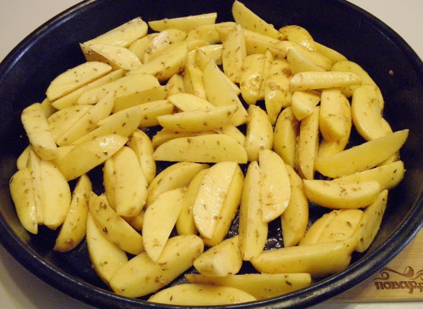 1. Этап. Картошка по-деревенски в духовке: Возьмите большой противень антипригарный. Разложите картофель в один слой, только так картофель будет целым и хорошо зажарится. Отправьте его в духовку на 40 минут. Следите!