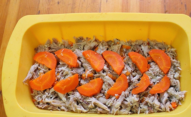 1. Этап. Куриный холодец в мультиварке редмонд: Выложите равномерно курицу, смешанную с чесноком, а поверх морковку в блюдо.