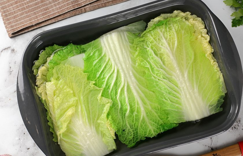 1. Этап. Голубцы из пекинской капусты: Оставшийся кочан разберите на отдельные листья, переложите их в подходящую широкую посуду, залейте кипятком и оставьте на 10 минут. Затем воду слейте, а листья обсушите.