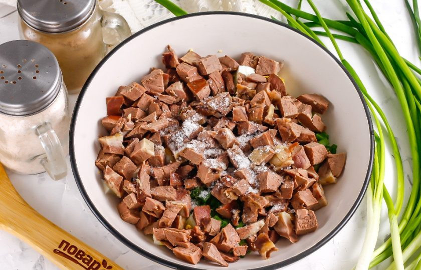 1. Этап. Салат из свиного сердца: Всыпьте соль. Молотый черный перец — по желанию.