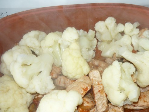 1. Этап. Свинина с цветной капустой: Тем временем ошпариваем кипятком капусту. Затем выкладываем ее сверху на мясо.