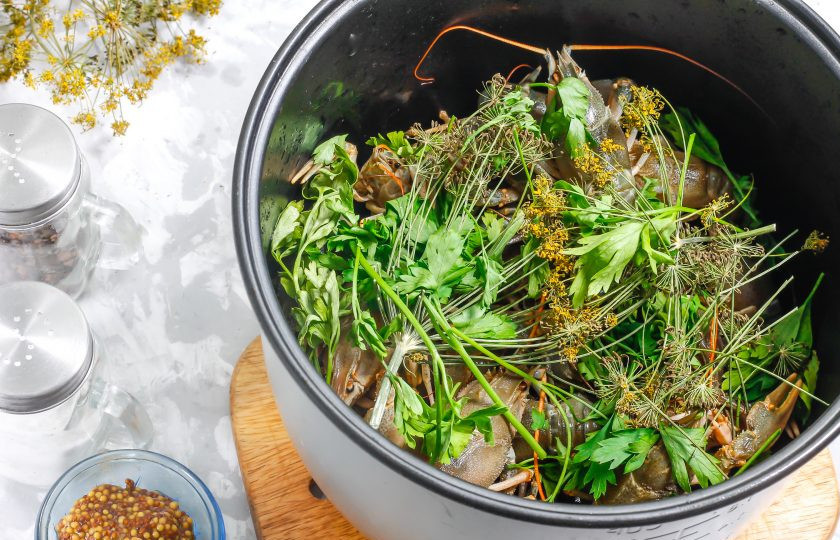 1. Этап. Раки в мультиварке: Промойте зелень и выложите ее в чашу. Добавьте зонтики укропа и лавровые листья для аромата.