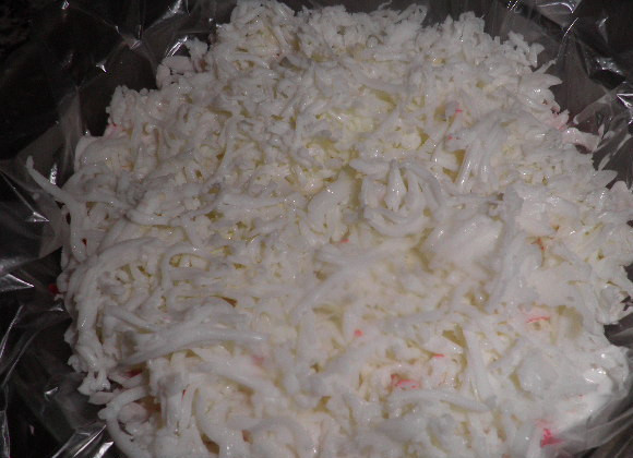 1. Этап. Салат-торт Для милых дам: Крабовые палочки разморозить и мелко нарезать.Первый слой выложить из половины получившегося тертого картофеля, смазать его небольшим количеством майонеза. Следующий слой салата формируется из тертых яичных белков, которые смазываются майонезом. На белки выкладывается оставшаяся картошка, далее слой из морковки, который также смазывается майонезом. Затем выложить слой из крабовых палочек.