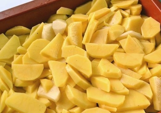 1. Этап. Горбуша с картофелем в духовке: Теперь смазываем формы для запекания сливочным маслом и выкладываем на нее кусочки картофеля.