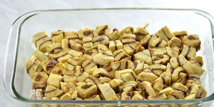 1. Этап. Сладкая тыквенная запеканка: В форму для выпечки нарежьте холодные булочки небольшими кусочками. Предварительно смажьте дно маслом.