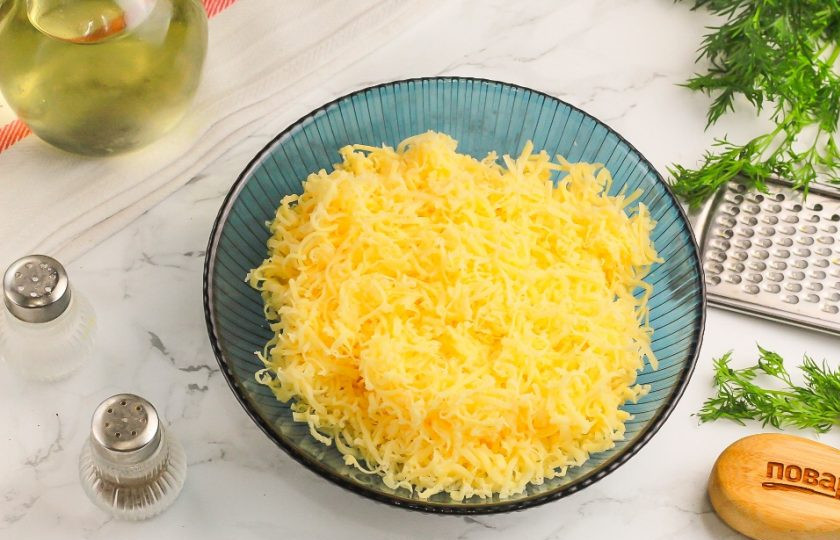 1. Этап. Блинные рулетики с начинкой: Первым делом приготовьте начинку: твердый сыр натрите на терке с мелкими ячейками в пиалу или креманку. При желании можно нарезать мелкими кубиками.