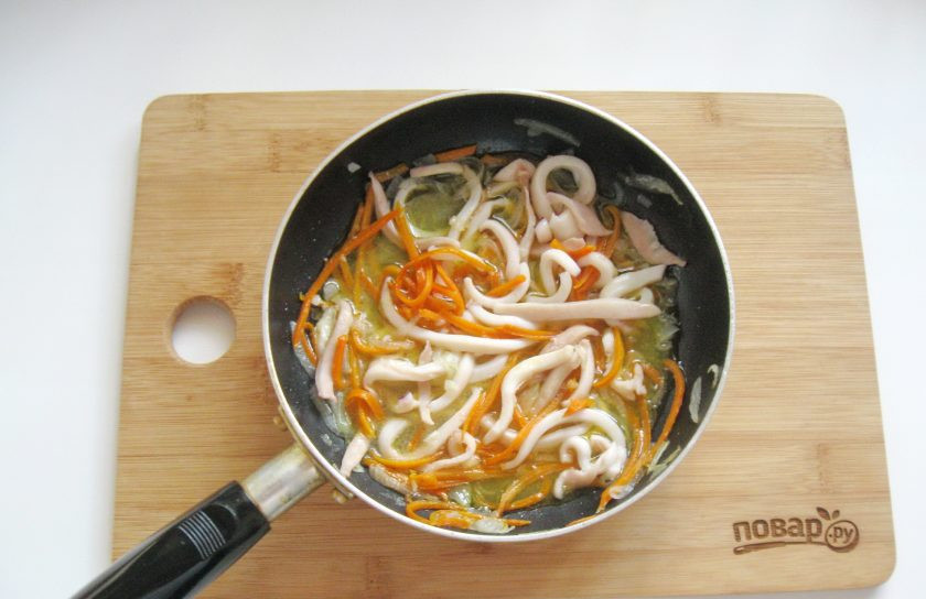 1. Этап. Кальмары с луком на сковороде: Накройте сковороду крышкой и тушите кальмары с луком и морковью перемешивая 3-4 минуты. При желании можно в конце добавить измельченный чеснок.