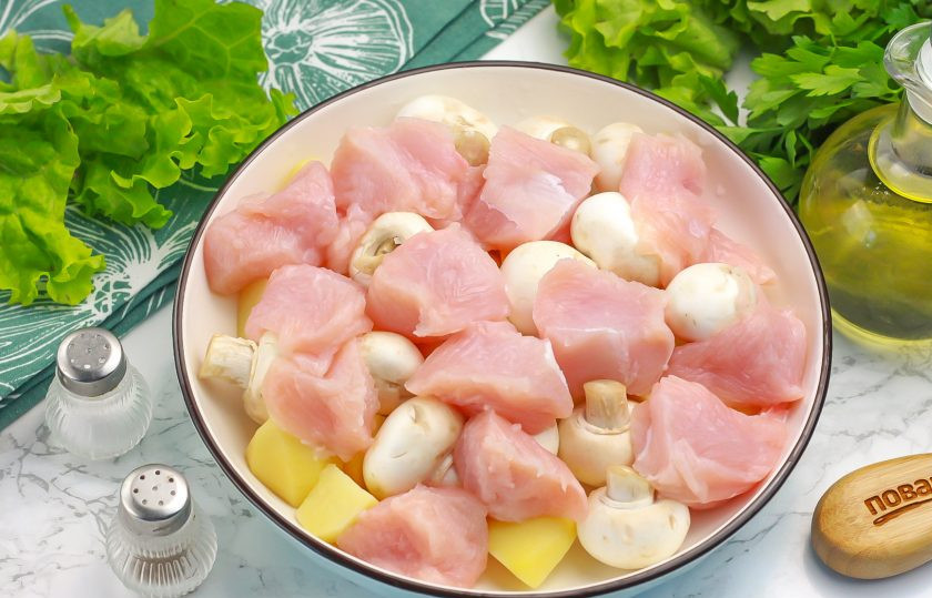 1. Этап. Индейка с картошкой и шампиньонами в духовке: Зачистите мясо индейки от жил и пленок, нарежьте порционными кусочками и добавьте в тарелку к остальным ингредиентам.