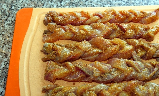 1. Этап. Запеченное филе сома: 4. Чтобы филе выглядело интереснее на столе можно нарезать его тонкими полосками и сплести вот такие косички. Соедините масло с куркумой и шалфеем, смажьте при помощи кисточки филе. Выложите на горячую решетку и запекайте буквально минут 10-12.