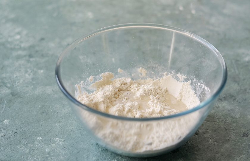 1. Этап. Соевые пельмени: Смешайте муку с солью. Постепенно вливайте воду.