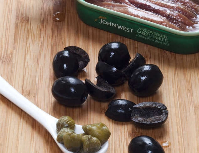 1. Этап. Салат по-тоскански: Оливки разрезать или разломать на пополам и вынуть косточки. Открыть банку с анчоусами. Подготовить каперсы.