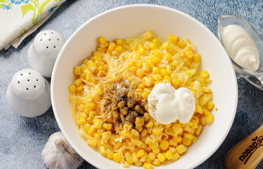 1. Этап. Салат с ананасом, сыром и кукурузой: Добавьте кукурузу, предварительно слив с банки жидкость, майонез по вкусу, соль и молотый перец.