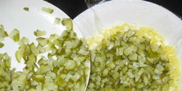 1. Этап. Салат из соленых огурцов без майонеза: 2. Дальше важно застелить глубокую миску полиэтиленовой пленкой, салат мы будет потом переворачивать. Сначала выкладываем сырно-яичный слой, затем промажем его сметаной. Потом — горошек и огурчики.