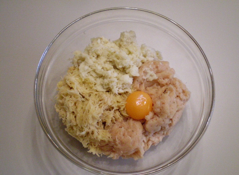 1. Этап. Куриное суфле в духовке: Картофель натрите на терке и добавьте в куриное мясо. Туда же введите желток, взбитый белок и хлеб с молоком.