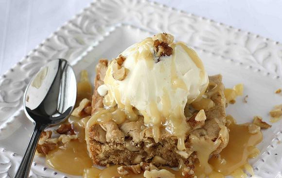 1. Этап. Ореховые пирожные со сливочным соусом: 5. Перед подачей на стол вы можете разогреть пирожные на чугунной сковородке или в микроволновой печи в течение примерно 25 секунд. Добавить шарик ванильного мороженого сверху, затем полить теплым соусом и посыпать сверху рублеными грецкими орехами.