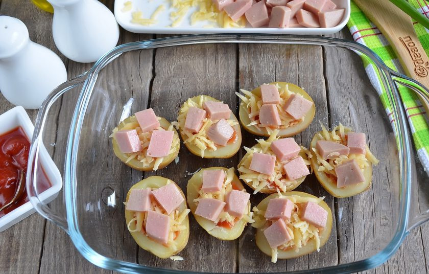 1. Этап. Пицца в картофельных лодочках: Сверху распределите кусочки колбасы или сосиски, порезанные колечками. Отправьте в духовку картофельные лодочки на 5 минут, температура — 200 градусов.