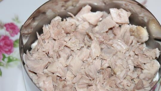 1. Этап. Салат Гранатовый браслет с сыром: Филе отварите в подсоленной воде до готовности. Затем остудите его, мелко нарежьте и выложите нижним слоем салата, смазав майонезом. Можете взять разъёмную форму.