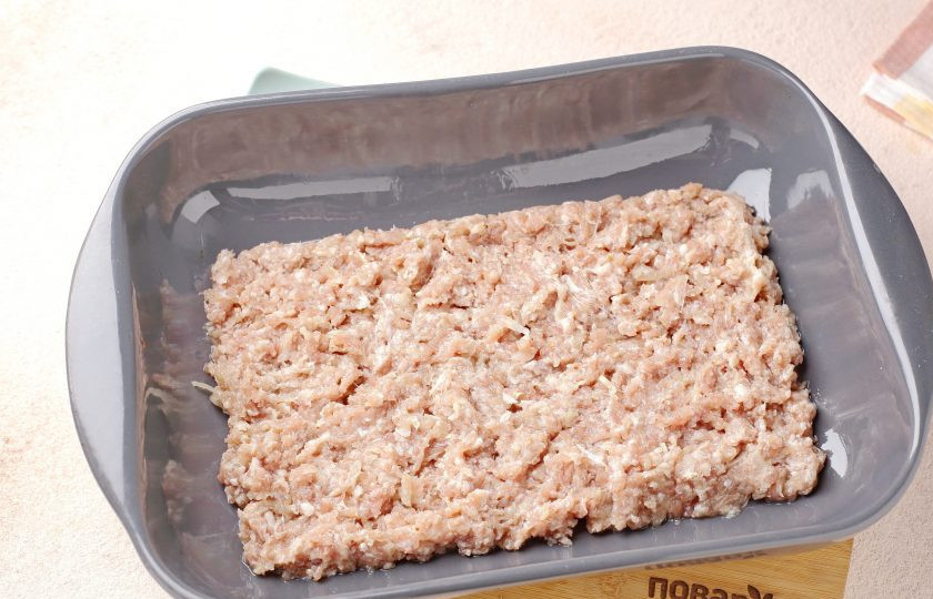 1. Этап. Запеканка из фарша с яблоками: Переложите фарш в смазанную маслом форму. Толщина слоя примерно 3-4 см.